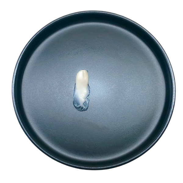 Time Freeze Facial Cream content on a black plate, showcasing the viscosity and texture of the serum.