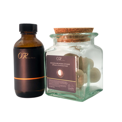 Brown bottle and glass jar with cork lid containing wooden balls on a white background