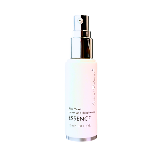 A 30 ml spray bottle of Essence Detox and Brightening Rice Yeast Essence by Origin Refined, featuring a white bottle with a soft pink tint near the bottom, a silver pump, and black text, set against a plain white background.