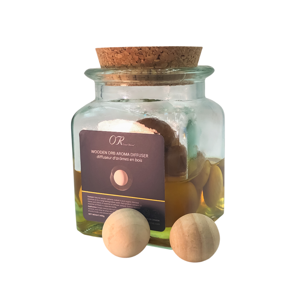 Glass jar with cork lid containing wooden Orr Arima diffuser and bath bombs on a white background