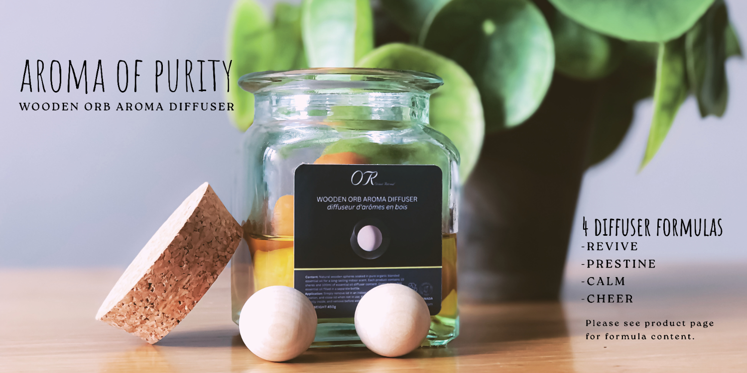 Wooden orb aroma diffuser with a glass jar on a wooden surface, surrounded by greenery.