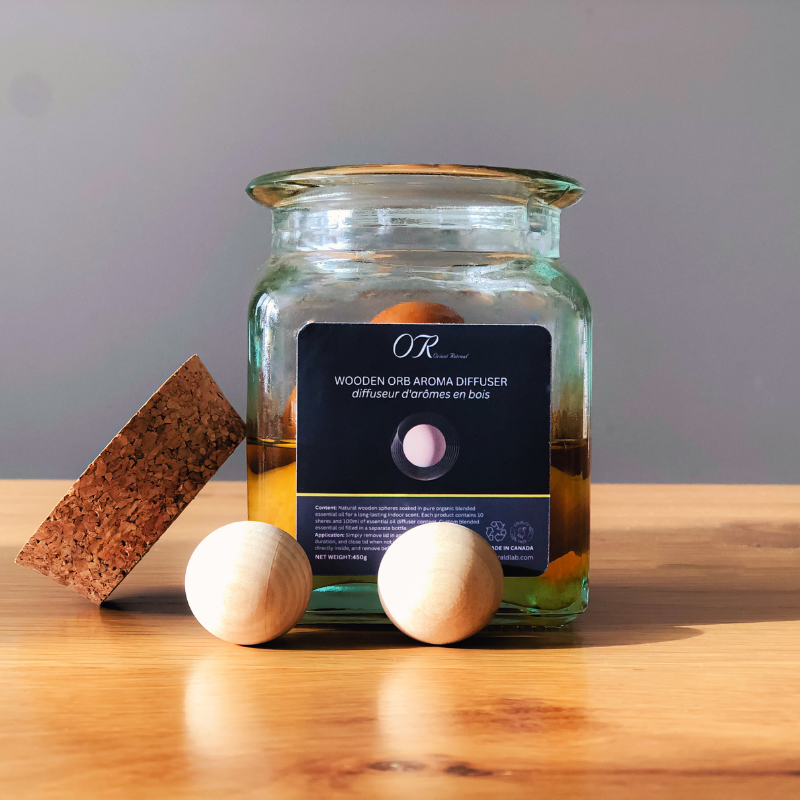 Aromatherapy diffuser with wooden orb and sponge on a wooden surface