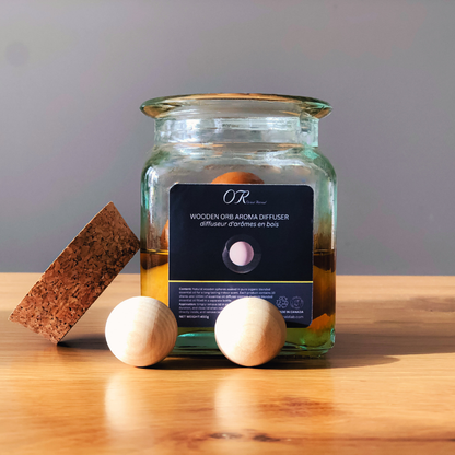 Aromatherapy diffuser with wooden orb and sponge on a wooden surface