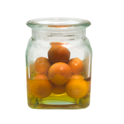 Clear glass jar filled with oranges on a white background